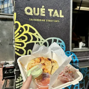 Two pupusas served with curtido (pickled cabbage slaw), tomato salsa, and cilantro crema.