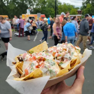 a person holding a plate of nachos