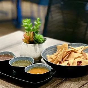 two bowls of salsa and chips on a table