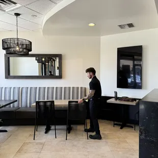 Inside seating to the left of the register.