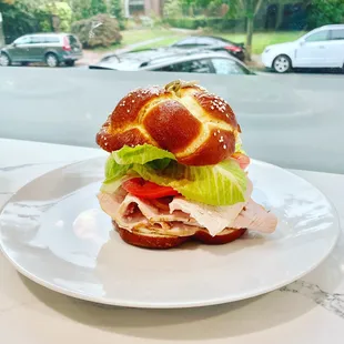 Queen Anne Turkey Sandwich: Oven roasted turkey breast, tomato, lettuce, and mayo our house-made challah pretzel roll!