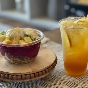 a glass of orange juice and a bowl of macaroni and cheese