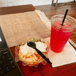 a table with a laptop and a bowl of food