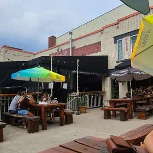 people sitting at tables under umbrellas