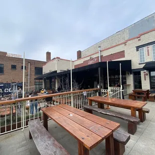 a view of a patio with benches and tables