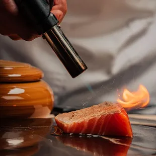 a chef cooking a piece of salmon