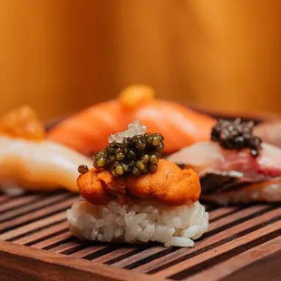 a variety of sushi on a bamboo tray