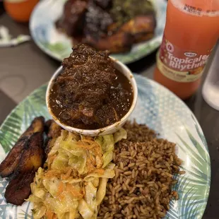 Oxtail plate with cabbage, rice, and plantains.