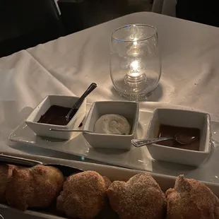 a plate of donuts and dipping sauces