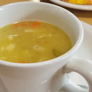 a cup of soup on a plate