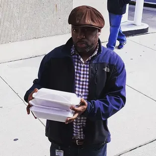 a man holding a box of food