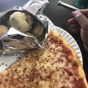 a slice of pizza on a paper plate