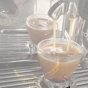 a coffee being poured into a cup