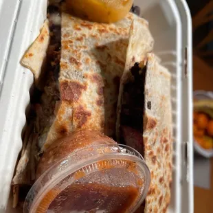 a plastic container filled with quesadilla