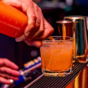 a bartender pouring a drink at a bar