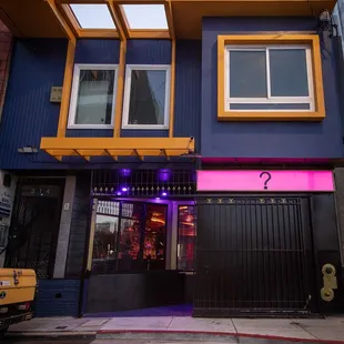 a blue and yellow building with a neon sign