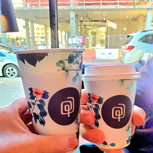 two cups of coffee in front of a window