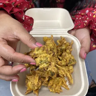 a woman holding a container of food
