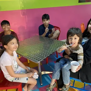  a group of children sitting around a table