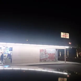the outside of a liquor shop at night