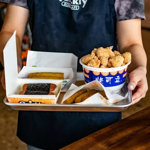 a person holding a tray of food