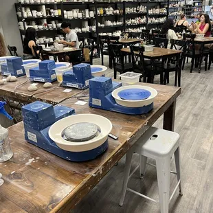 Pottery wheels, and tables and items along the wall you can see the items you can buy and paint