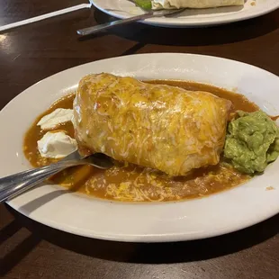 Smothered Meat-lovers burrito in front, veggie breakfast burrito in the background