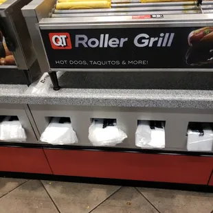 a roller grill with hot dogs, tacos, and more