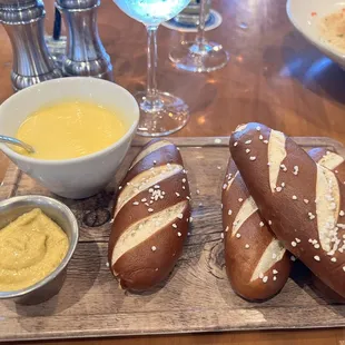 a table with bread, mustard, and dip