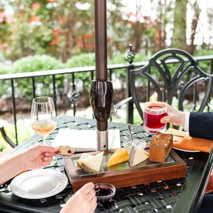 a woman and a man sharing a glass of wine and cheese