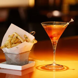 a glass of wine and a basket of french fries