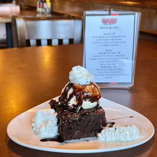 a piece of brownie with ice cream and caramel