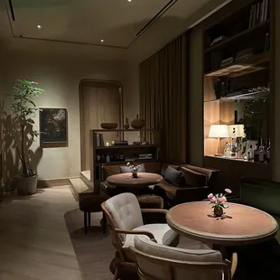 a dimly lit living room with a bar in the background