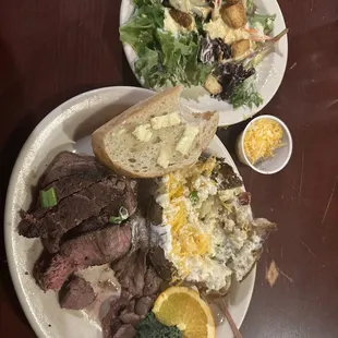 Loaded baked potato with filet mingon, bread and side salad.