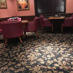 a dining room with red chairs and tables