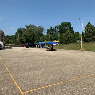 a parking lot with tables and umbrellas