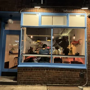 a man sitting in the window of a restaurant