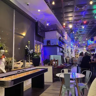 Shuffleboard table, lights, some seating, bar area