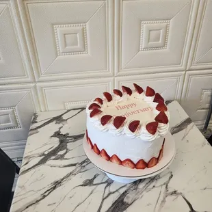 a strawberry cake on a marble table