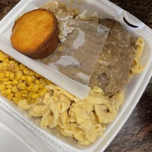 Smothered porkchop, corn, Mac, and cornbread