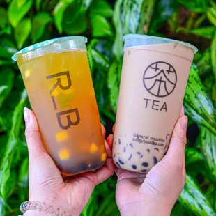 a person holding two drinks