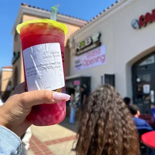 a person holding a cup of juice