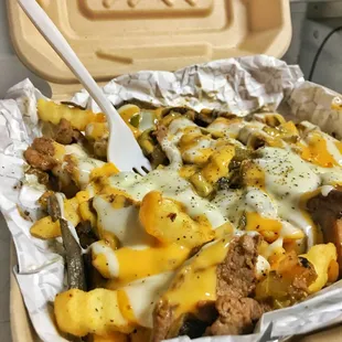 Cheeseteak fries - heap of fries topped with juicy ribeye, jalapenos, onions, and bell peppers smothered in cheese!