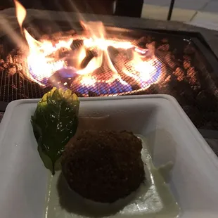 a plate of food in front of a fire