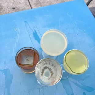 four glasses of alcohol on a blue table