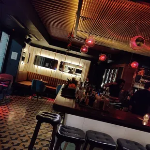 a dimly lit bar with stools