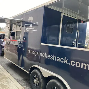 ows a man standing in front of a food truck