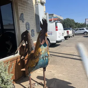 a rooster statue in front of a restaurant
