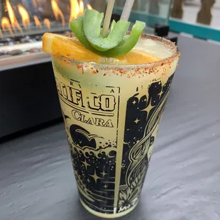 a drink with a lime garnish