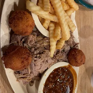BBQ pulled pork plate, fries, baked beans, and hush puppies